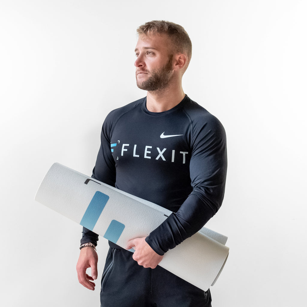 Man holding FlexIt yoga mat in hand.