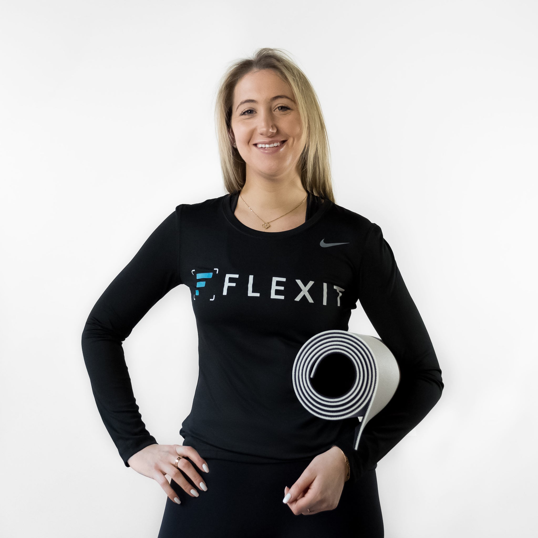 Woman holding FlexIt yoga mat in hand.